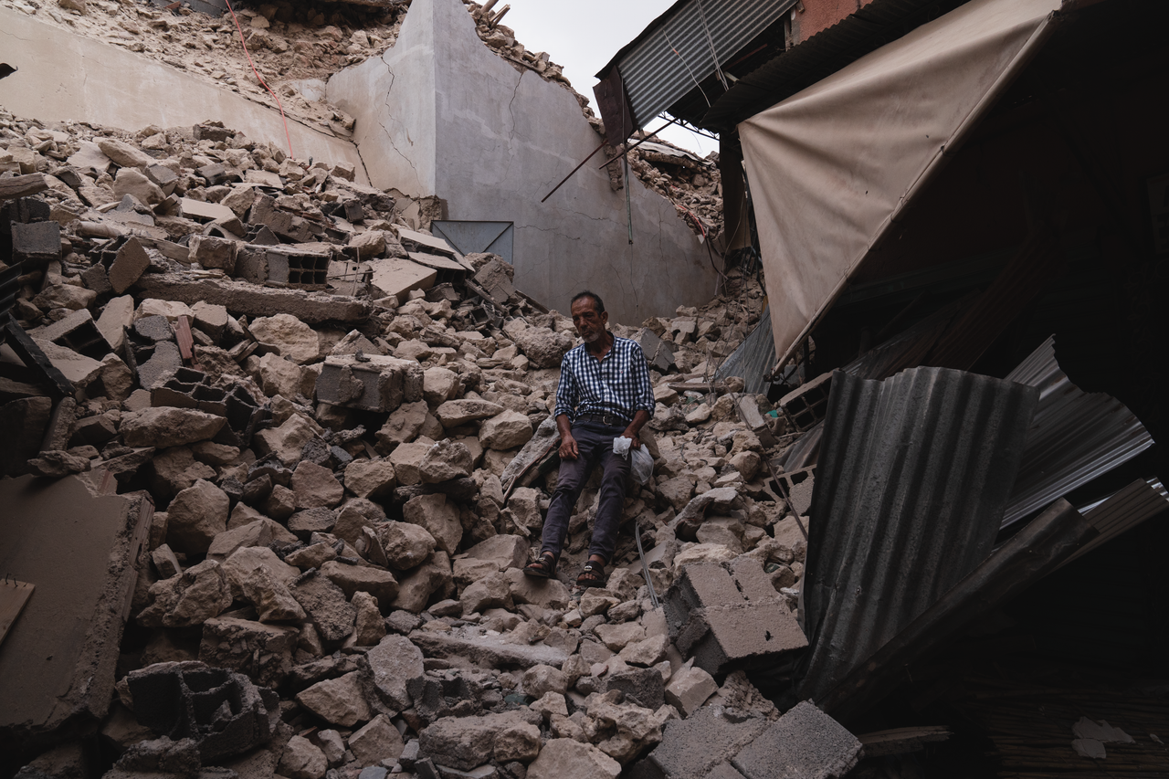 about-img A man sits amidst collapsed buildings and debris following an earthquake in Marrakesh, Morocco.