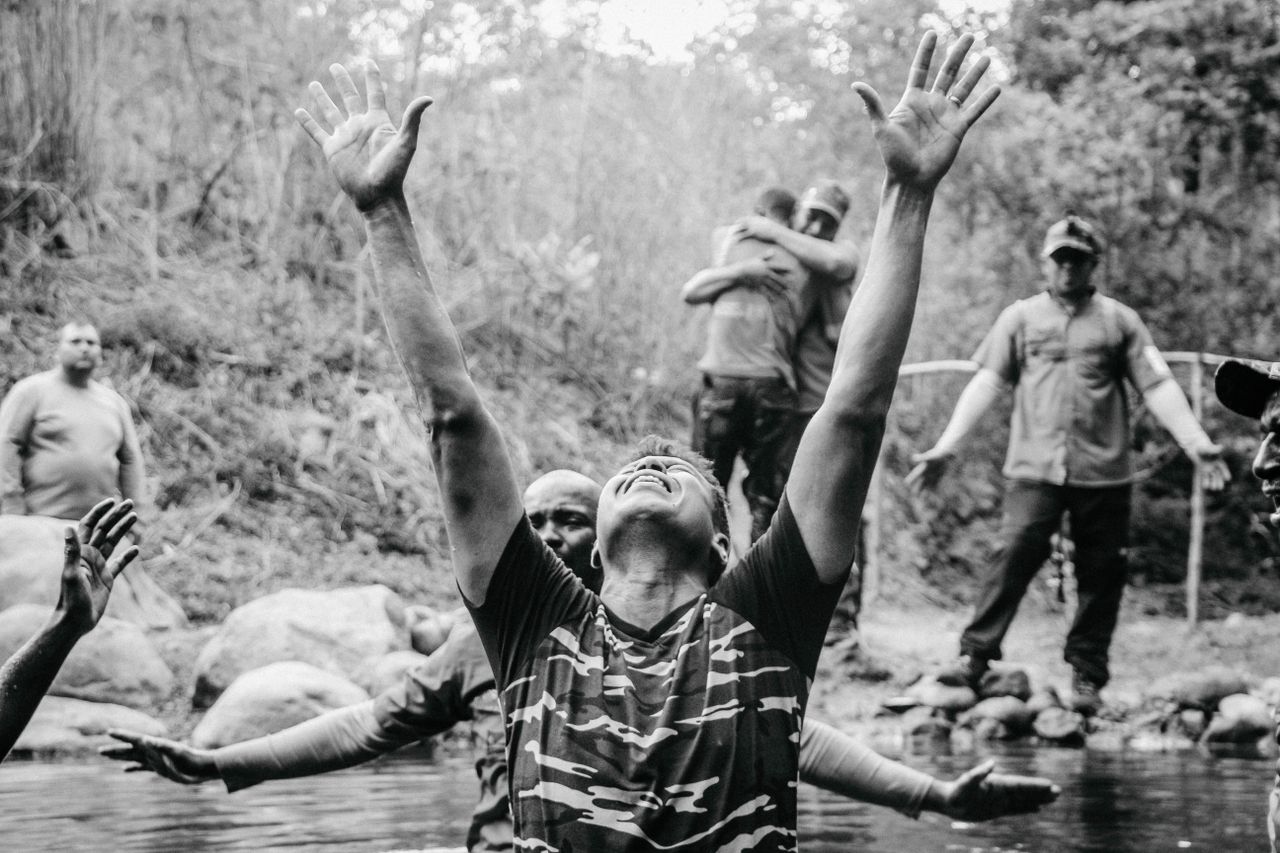 A group of men experiencing a spiritual baptism in a river in Panama, expressing joy and gratitude.
